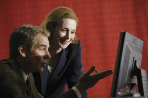 Two executives at watching results of e-mail campaign by opens, clicks and conversions. © Comstock Images. Purchased 8/2005 by Tempest Inc.